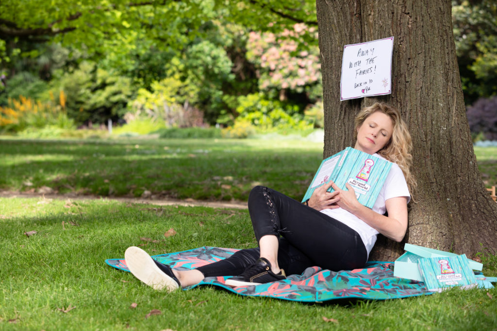 Lady sleeping under a tree with a book