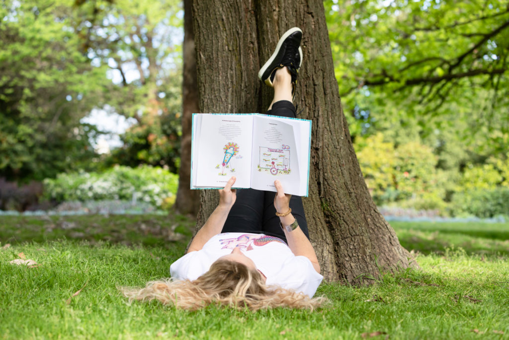 Lady reading a book under a tree