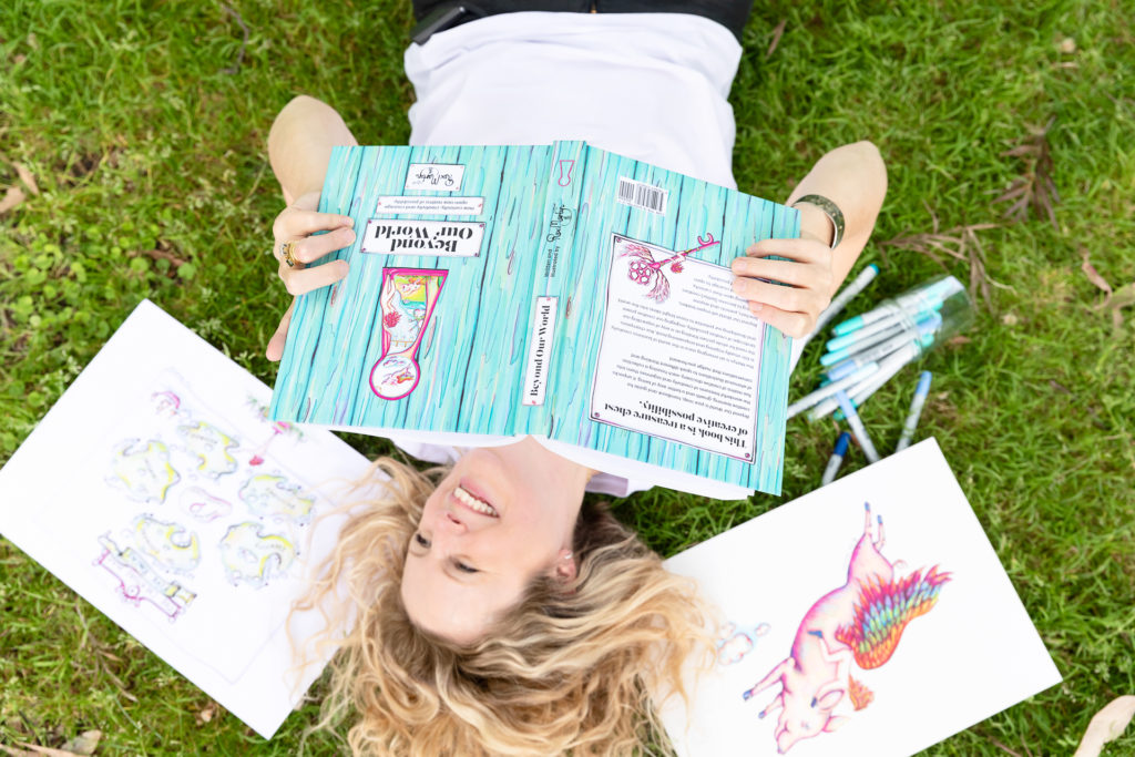 Lady laying on grass holding a book