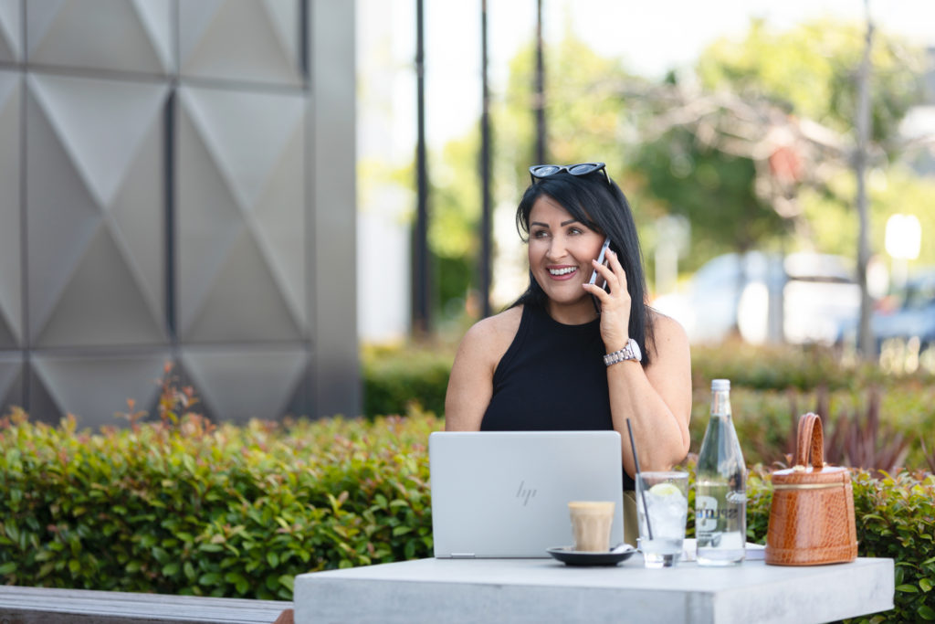 Business woman talking on her mobile at an outdoor cafe
