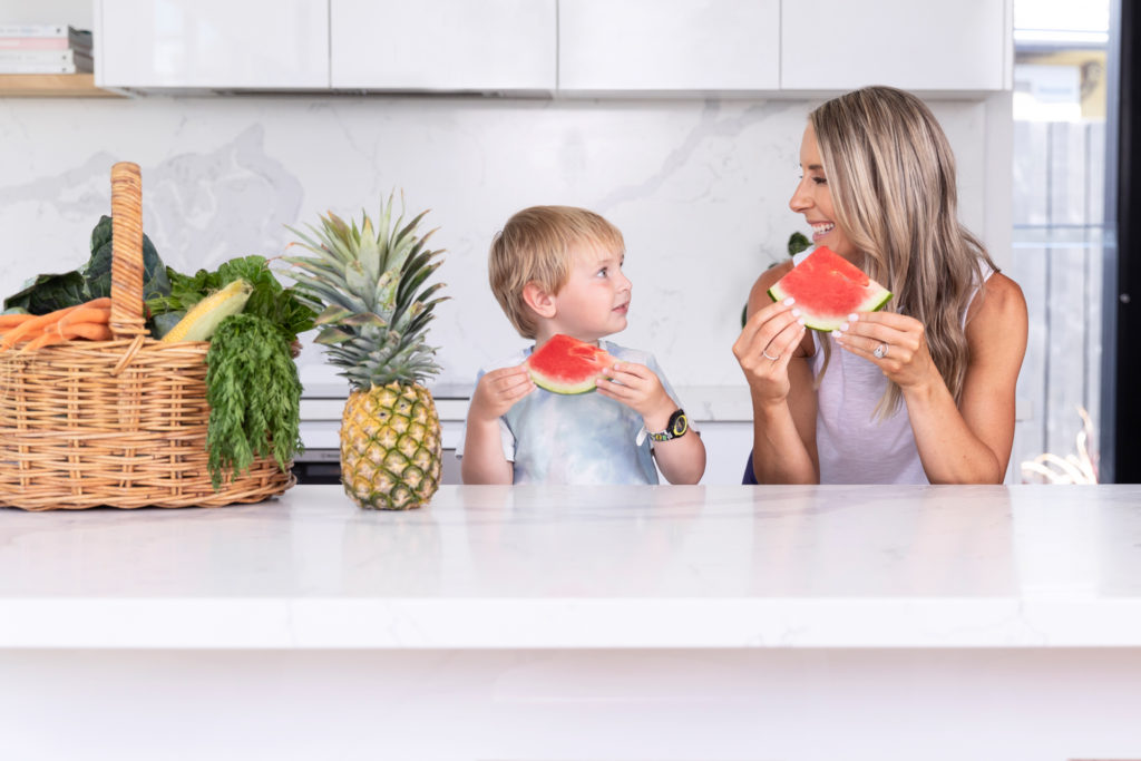 A working mum and her son eating watermelon
