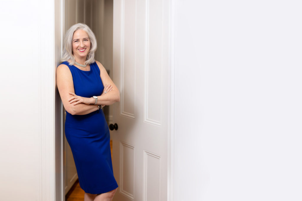 Portrait of a female business owner leaning in a doorway