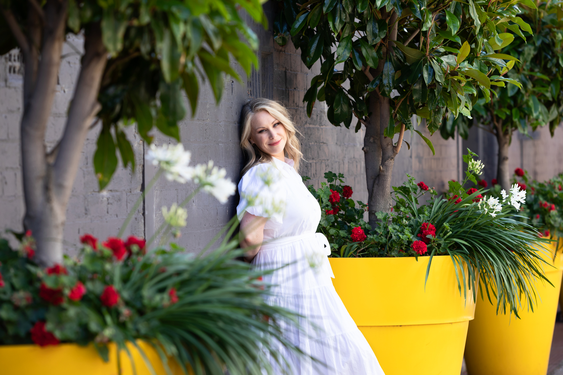 personal branding photo of a lady standing between planted yellow pots