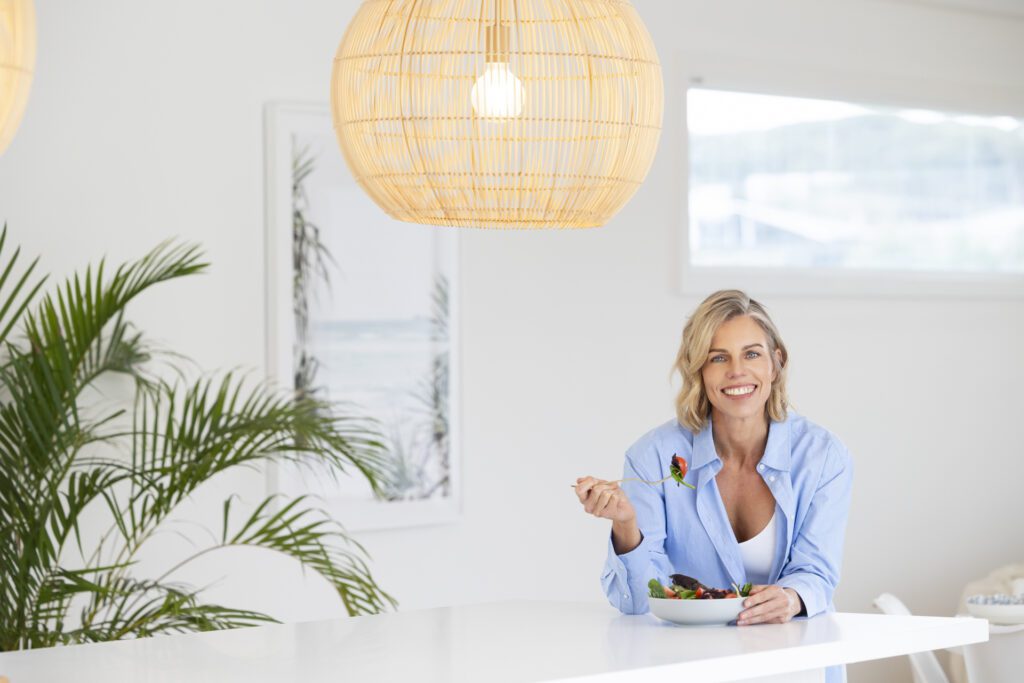 lady sitting at kitchen bench eating salad