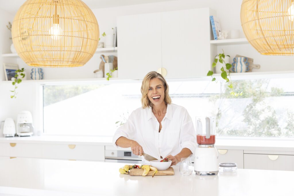 Lady at kitchen bench making a smoothy