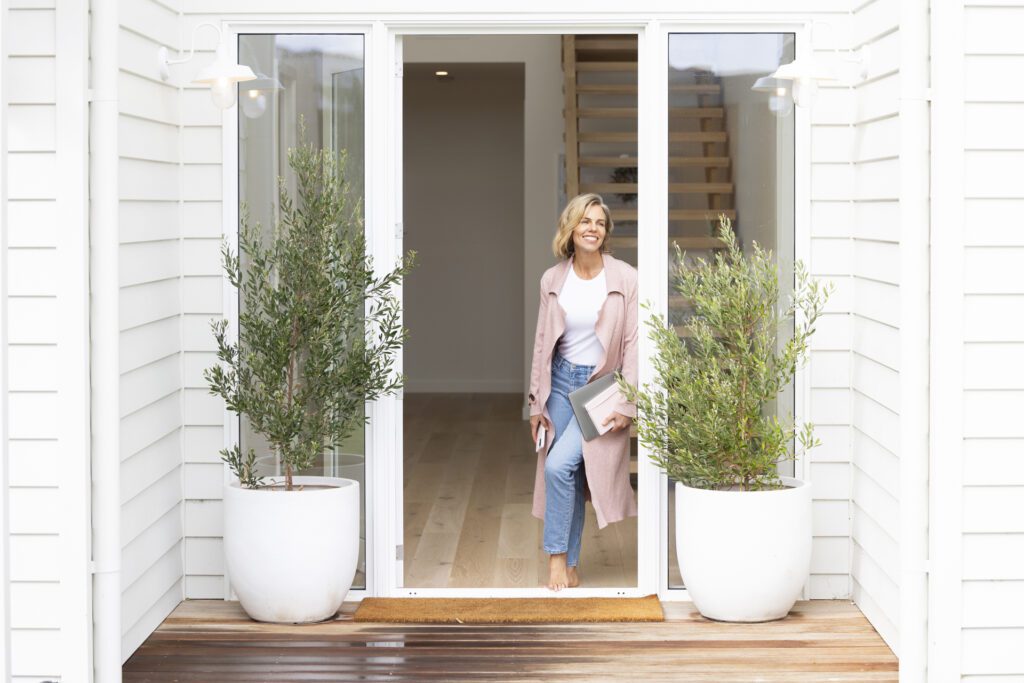 Lady standing in the front entrance of her home