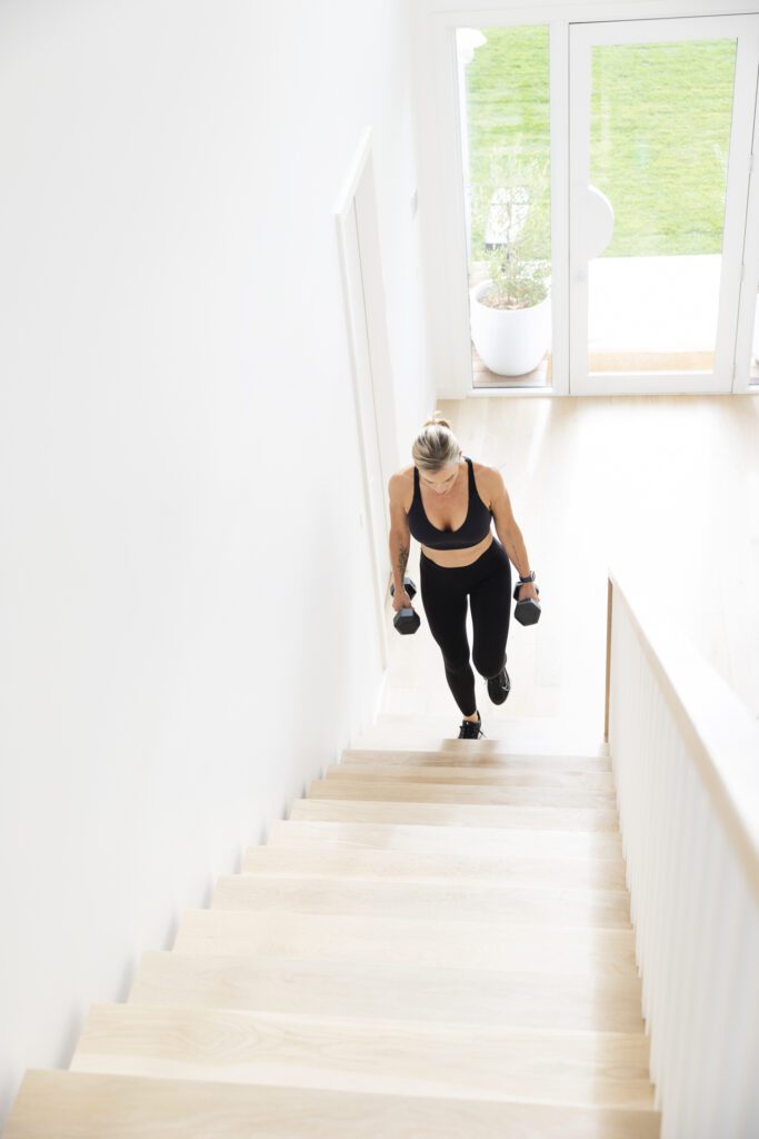 Lady carrying weights up the stairs