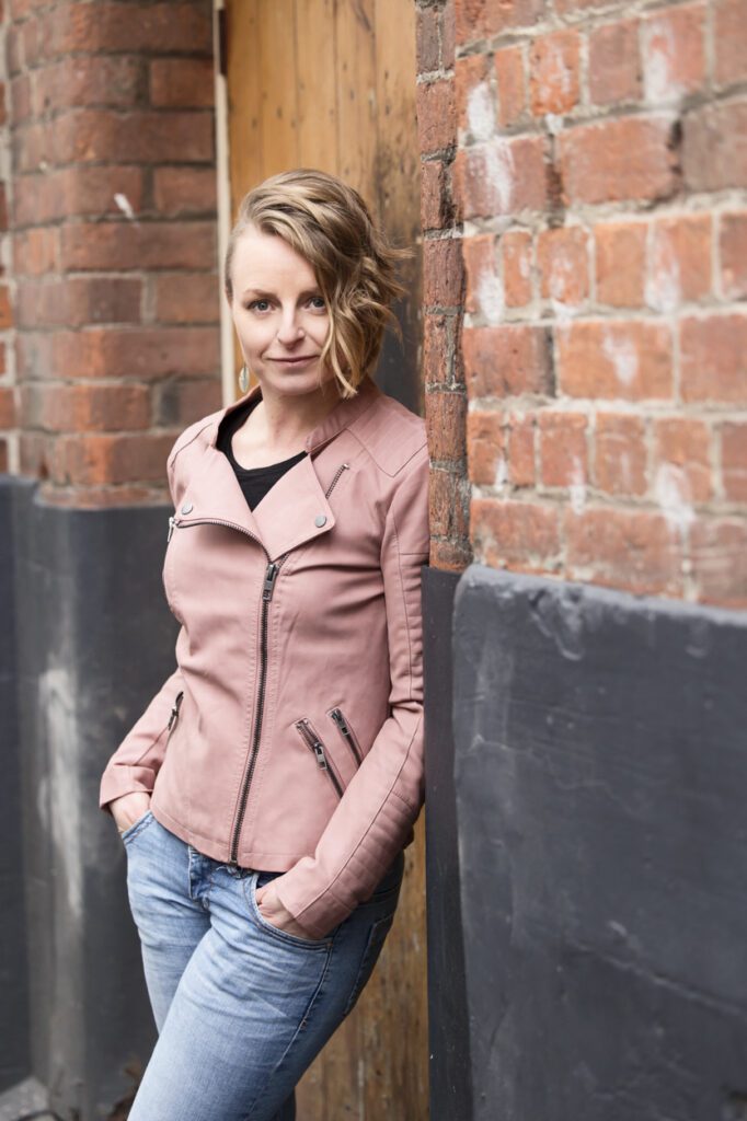 Lady in the doorway of a brick building in a laneway