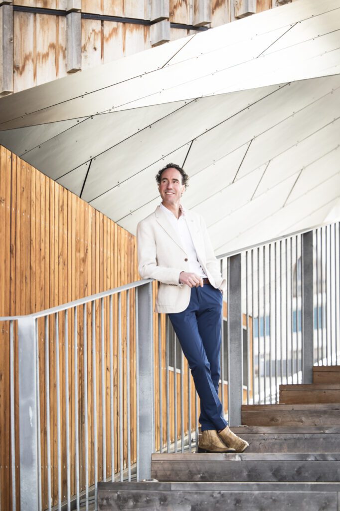 A man standing on the steps of a building leaning against the railing