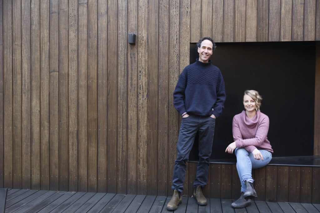 An image of a man standing and a lady sitting on a bench