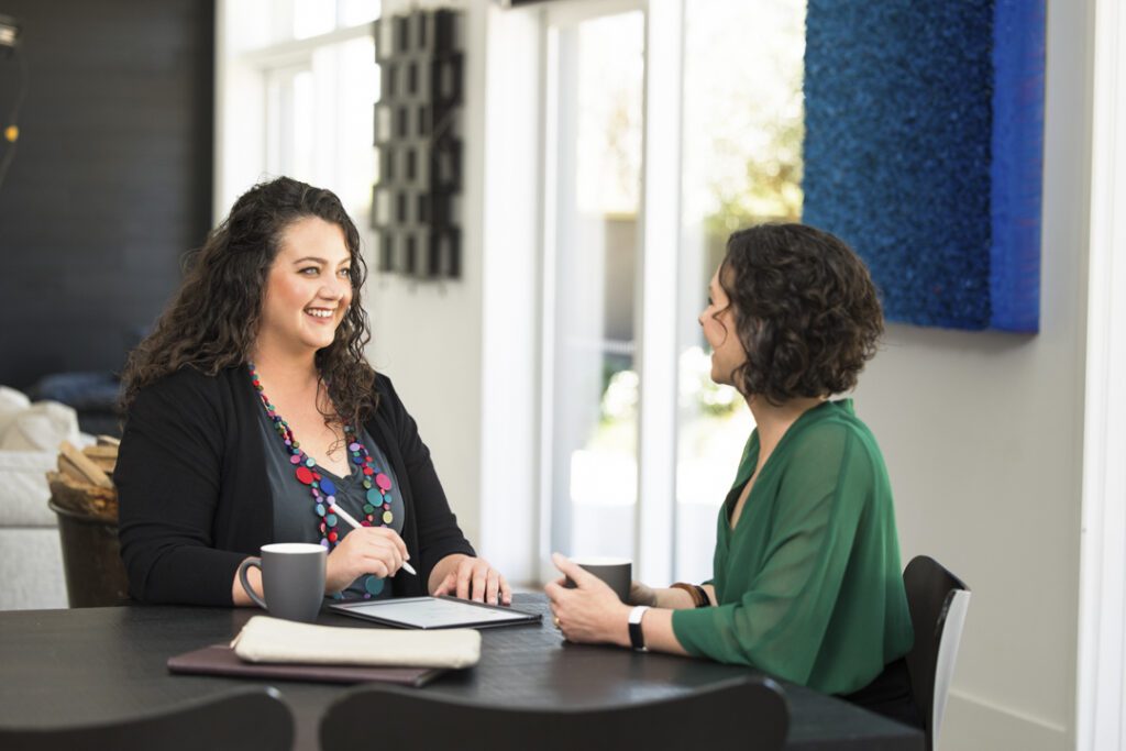 Two ladies sitting at a table talking