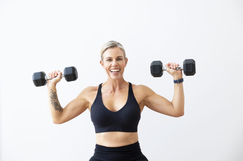 Lady holding weights doing shoulder exercises