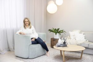 A personal brand photoshoot that captures a portrait of a lady wearing a white shirt and jeans sitting in a comfy lounge chair