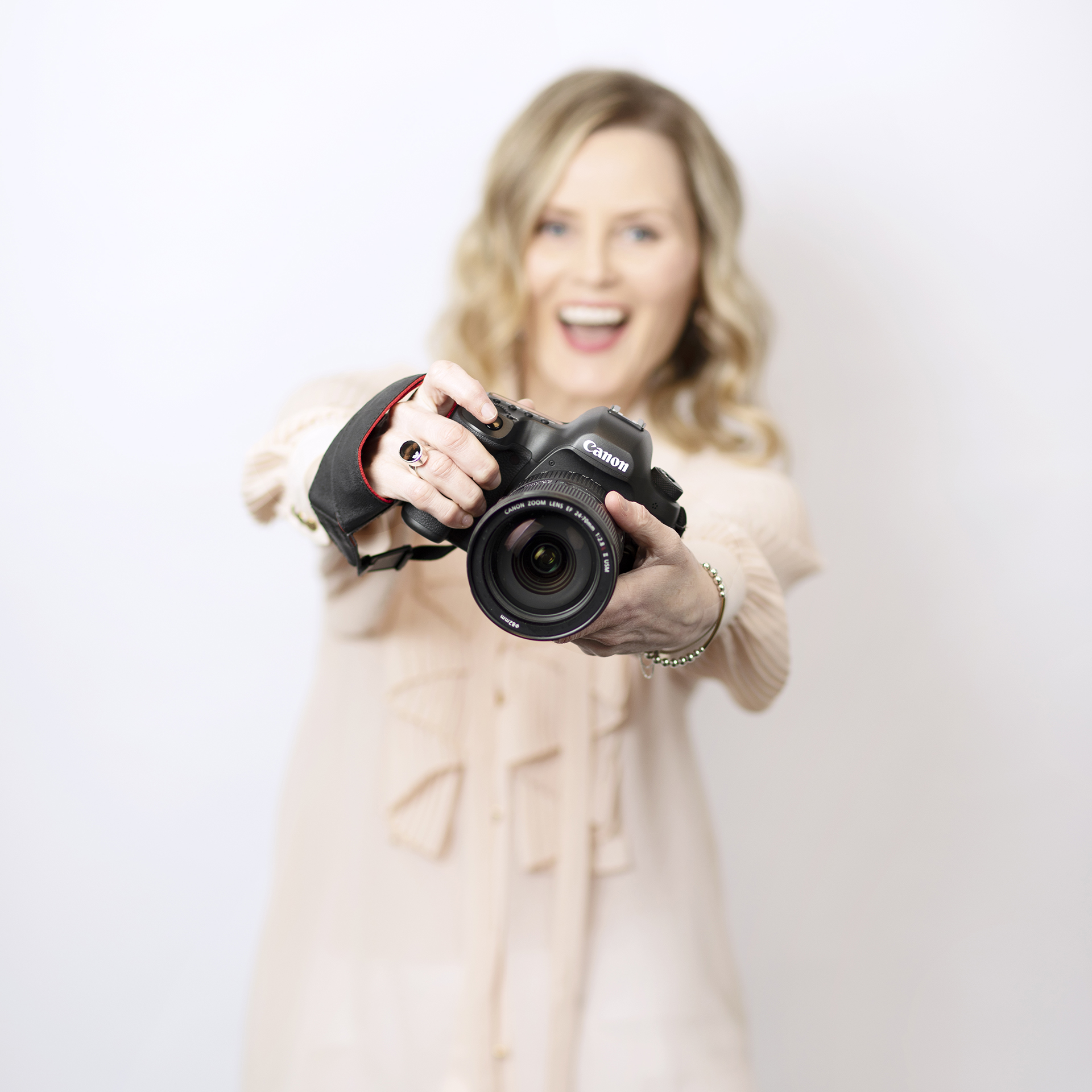 Photographer holding a camera with outstretched arms in front of them