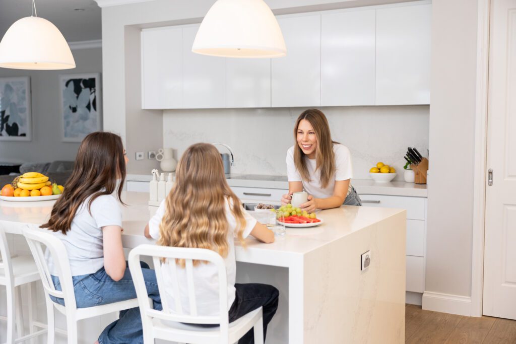 Female business owner in a kitchen with her kids after school