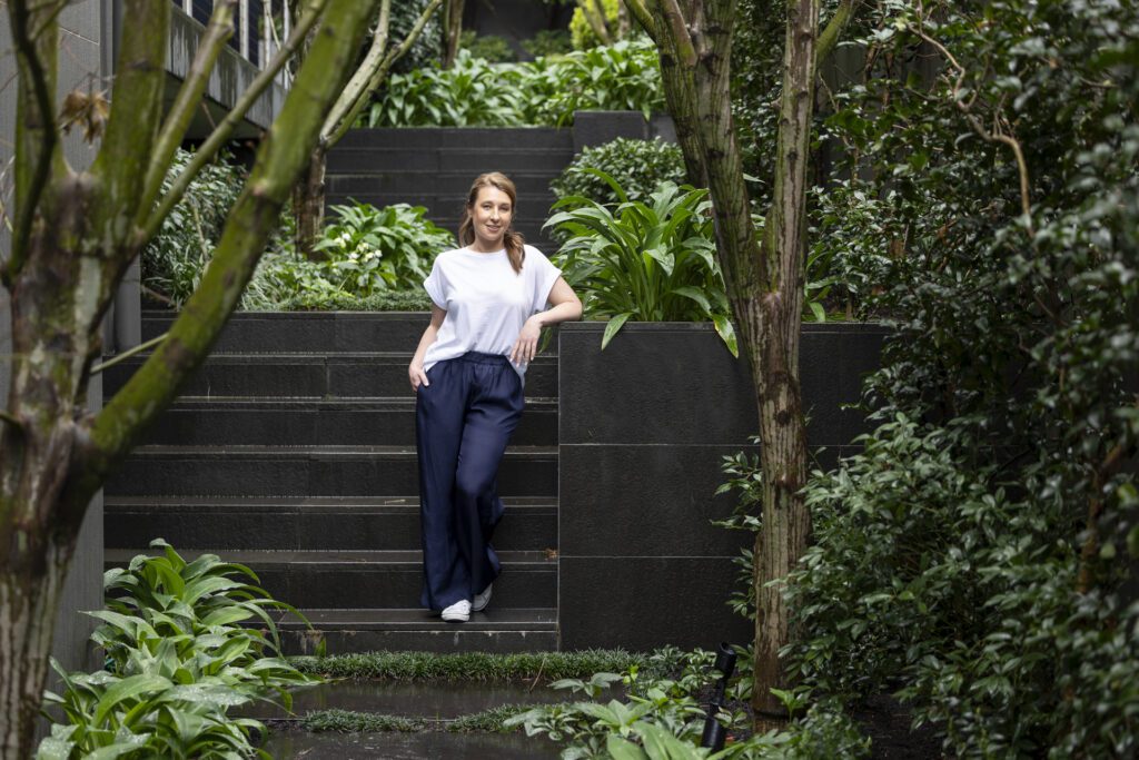 Personal Branding Photography of a female psychologist wearing a white top and navy pants in a garden